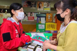 Relief worker hands basket of supplies to beneficiary in Japan