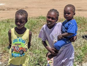 A Sudanese boy and girl. The girl on the right is holding a baby