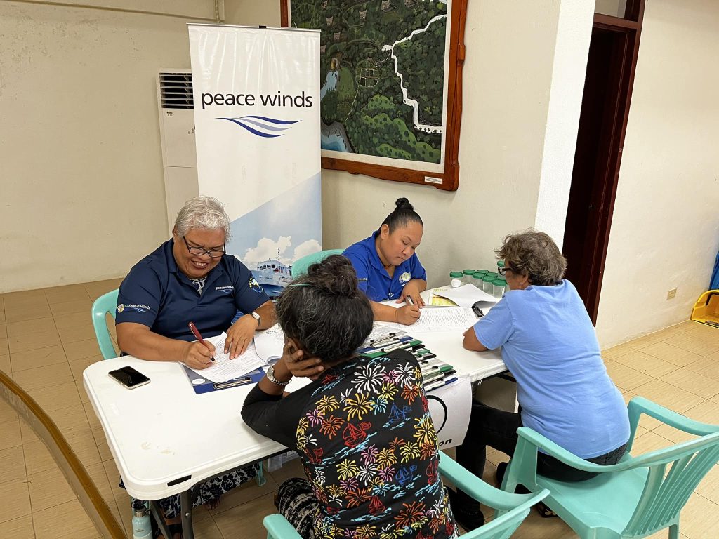 Two patients and two Peace Winds staff members sit at a table
