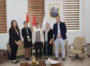 4 women and a man stand for a photo in an office