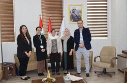 4 women and a man stand for a photo in an office